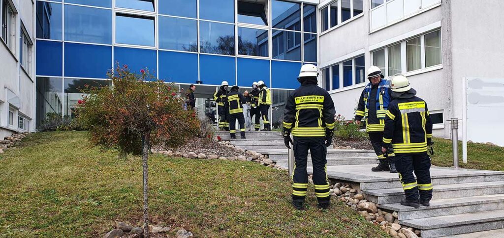 Einsatzkräfte vor dem verrauchten Eingangsbereich, Bild: Frank Hoffmann/Feuerwehr