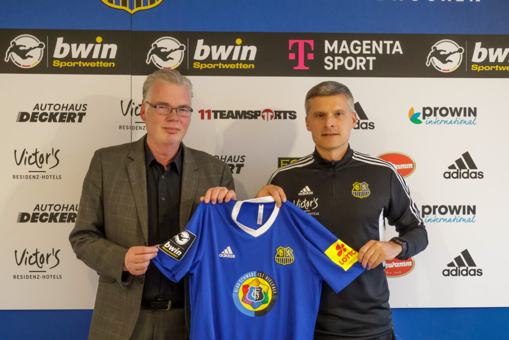 FCS-Aufsichtsratsmitglied Prof. Oliver Strauch und Cheftrainer Ruediger Ziehl präsentieren das Trikot mit dem Logo "Blauschwarz ist Vielfalt".