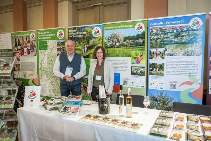 Peter Klein, Geschäftsführer der SaarSchleifeLand Touristik, und Monika Lambert-Debong, Sachgebietsleiterin Umwelt beim Landkreis Saarlouis, am Infostand zur Viezstraße. Foto: Gina Hartwich/Apfelwein International UG.