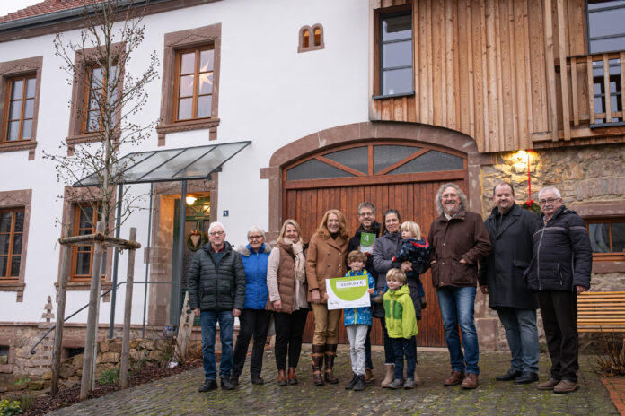 v.r.n.l.: Die Eltern der Hausbesitzer, Günter und Ilse Graf, MdL Sandra Quinten, Ministerin Petra Berg, Eigentümer Torsten Graf mit Frau Susanne und ihren drei Kindern, Architekt Lothar Bost, Ortsvorsteher Thomas Lamberti und der Vater von Susanne Graf, Hans Werner Willems.