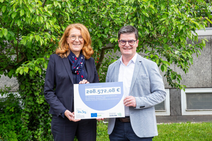 Ministerin Petra Berg (l.) übergibt Andreas Veit (r.), dem Bürgermeister der Gemeinde Nohfelden, einen Zuwendungsbescheid in Höhe von 208.572,08 Euro, Foto: MUKMAV/Kathrin Stockart