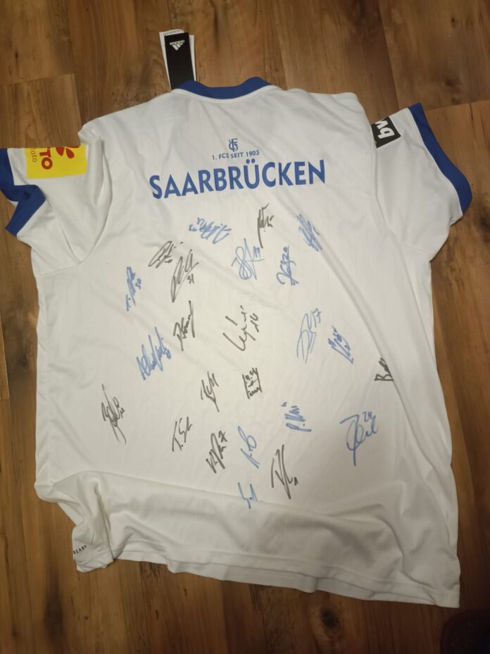 Dieses Trikot, unterschrieben von den Spielern der Mannschaft 22/23 des 1. FC Saarbrücken, wird verlost.