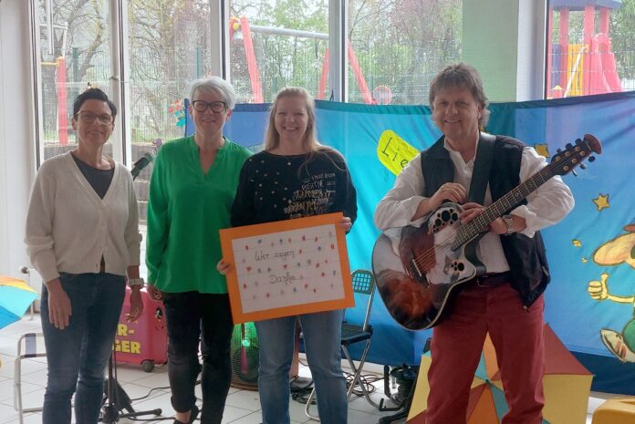 Eddi Zauberfinger begeisterte Kinder wie Erwachsene mit seinem musikalischen Auftritt in der Kita Wirbelwind im ehemaligen Losheimer Krankenhaus, von links: Silke Mertes (Gesamtleiterin kommunale Kitas), Sandra Berwian (Leiterin Kita Wirbelwind), Kita-Mutter und Spenderin Silke Simon und Kinderliedermacher Eddi Zauberfinger. Foto: Monika Priesnitz