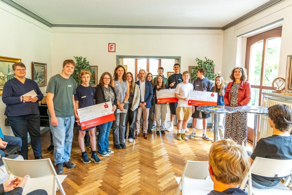 Die Schülerinnen und Schüler freuten sich mit ihrer Lehrerin Eva Bacher (re.) und Schulleiterin Heike Scholz (li.) über die Gutscheine der KSK, die von Filialleiter Stefan Ricci (Bildmitte) überreicht wurden. - Foto: Thomas Bastuck